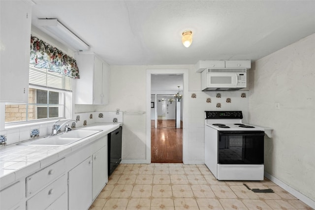 kitchen featuring white appliances, sink, tile counters, and white cabinets