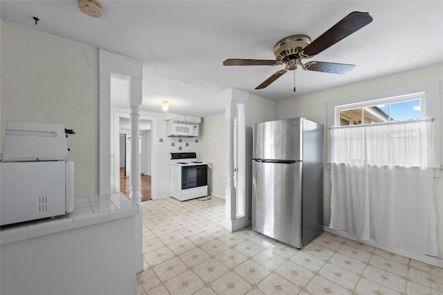 kitchen featuring white appliances, white cabinetry, ceiling fan, ornate columns, and tile counters