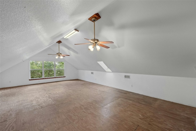 bonus room featuring vaulted ceiling with skylight, a textured ceiling, and ceiling fan