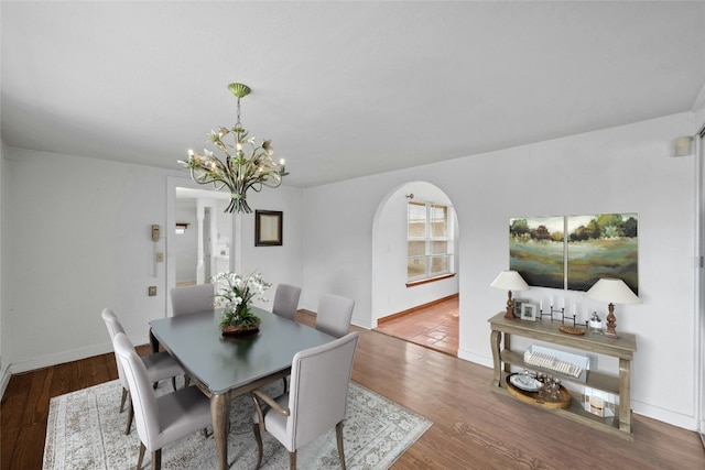 dining room with hardwood / wood-style floors and an inviting chandelier