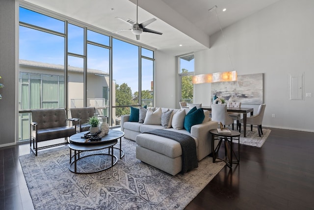 living room with dark wood-type flooring and ceiling fan