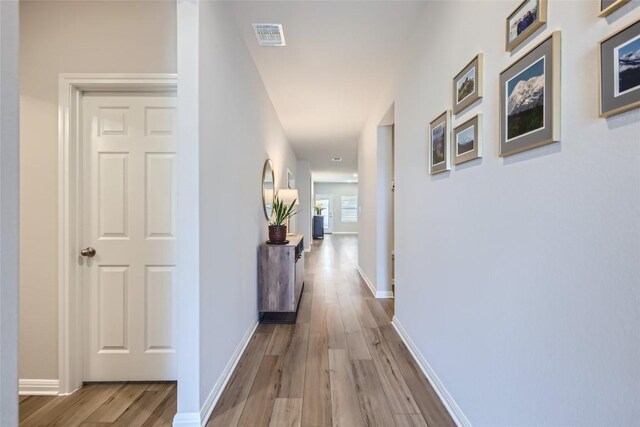 hallway with light hardwood / wood-style floors