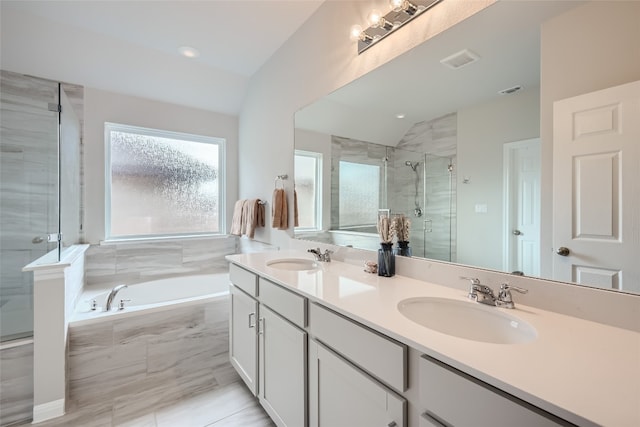 bathroom featuring vanity, separate shower and tub, and lofted ceiling