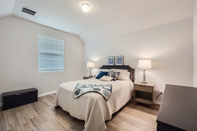 bedroom with light hardwood / wood-style floors and vaulted ceiling