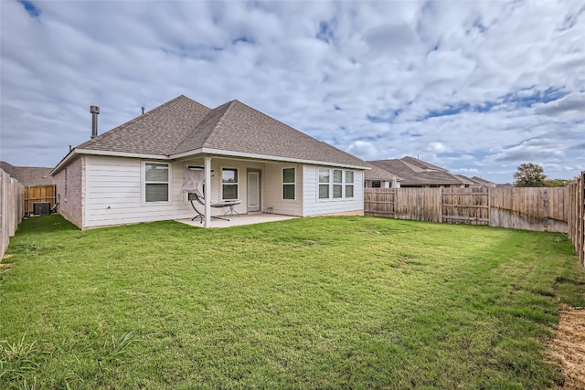 rear view of property featuring a lawn, cooling unit, and a patio