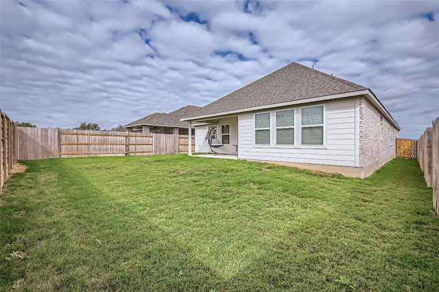 rear view of property featuring a lawn and a patio area