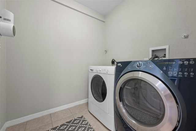 laundry area with washer and dryer and light tile patterned floors