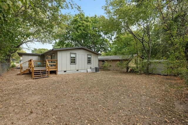 rear view of house featuring a wooden deck and central AC