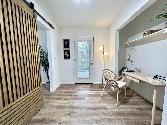 interior space with wood-type flooring and a barn door