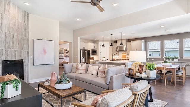 living room featuring dark wood-type flooring, a fireplace, and ceiling fan