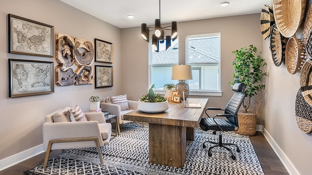 sitting room with dark wood-type flooring and an inviting chandelier