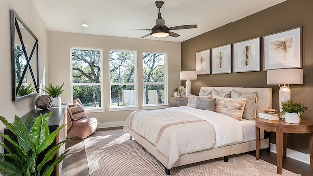 bedroom with ceiling fan and light hardwood / wood-style floors