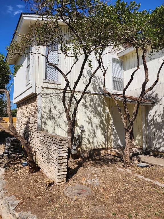 view of side of home with central air condition unit