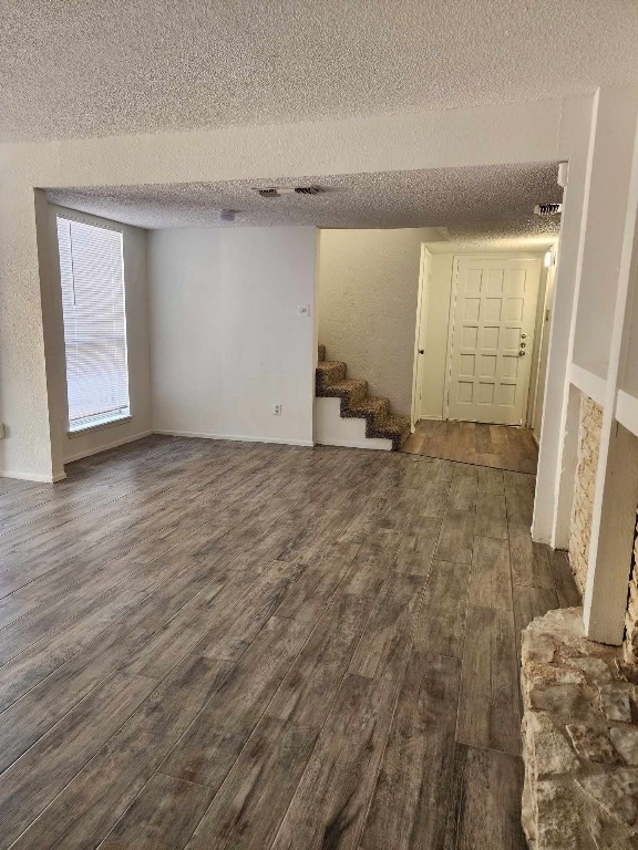 interior space with a textured ceiling and dark hardwood / wood-style floors