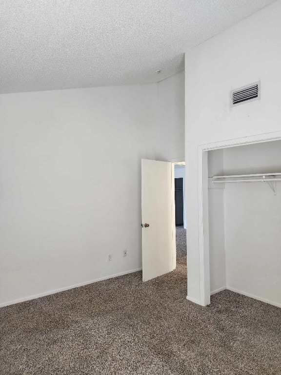 unfurnished bedroom with a textured ceiling, a closet, and carpet flooring