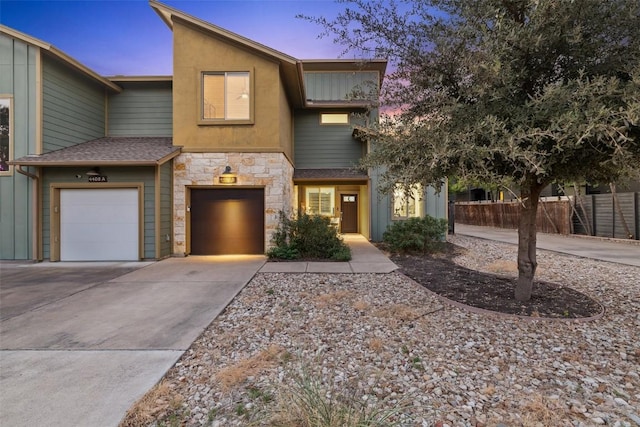 4408 Banister Ln Unit B, Austin, TX 78745 - view of front facade with concrete driveway, fence, stone siding, and a garage