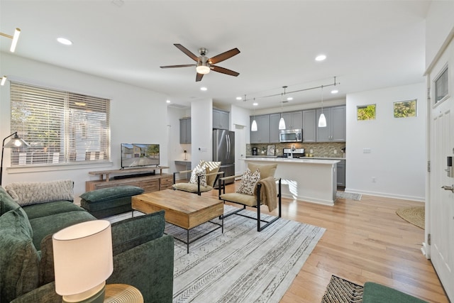 living room with ceiling fan and light hardwood / wood-style flooring