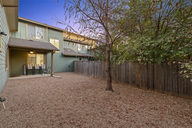 yard at dusk featuring a patio