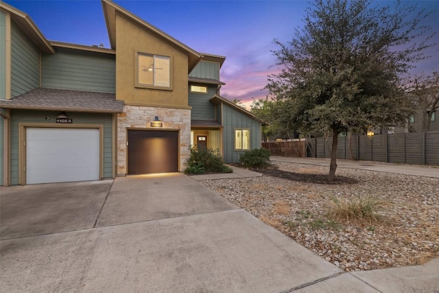 4408 Banister Ln Unit B, Austin, TX 78745 - view of property featuring an attached garage, driveway, fence, and stone siding
