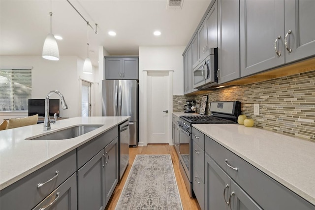 4408 Banister Ln Unit B, Austin, TX 78745 - kitchen featuring stainless steel appliances, visible vents, gray cabinets, a sink, and light wood-type flooring