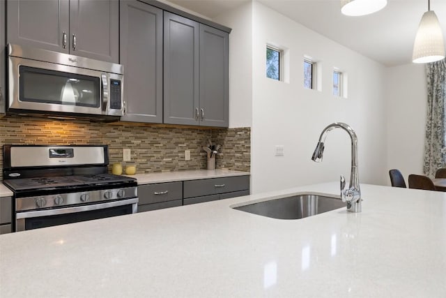 4408 Banister Ln Unit B, Austin, TX 78745 - kitchen featuring appliances with stainless steel finishes, gray cabinets, decorative backsplash, and a sink