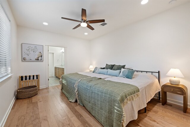 bedroom with ensuite bathroom, light wood-type flooring, and ceiling fan