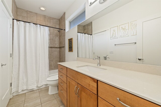 full bathroom featuring vanity, shower / bath combo with shower curtain, toilet, and tile patterned flooring