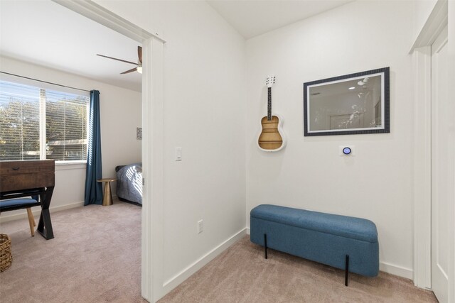 sitting room featuring light carpet and ceiling fan