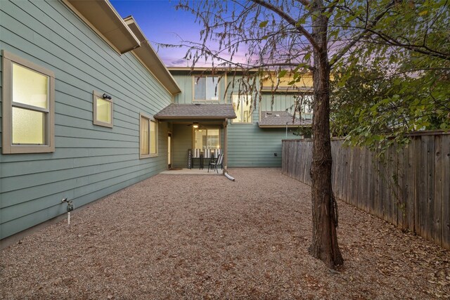 back house at dusk with a patio