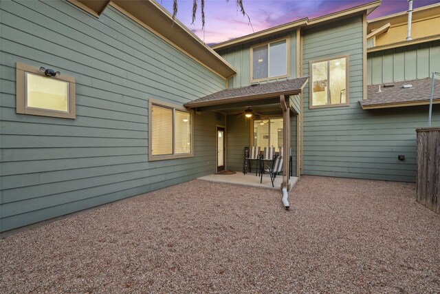 back house at dusk with a patio area