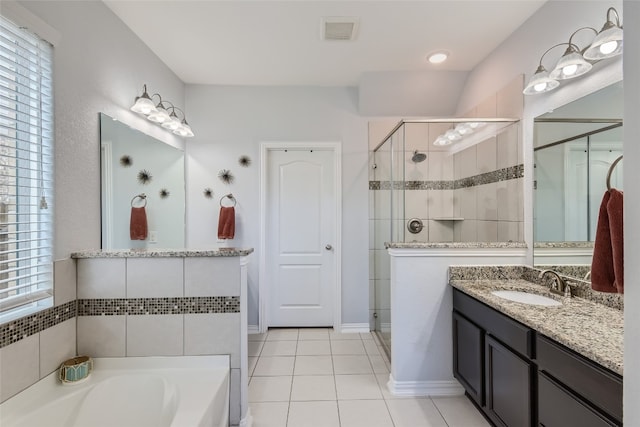 bathroom with tile patterned flooring, vanity, and plus walk in shower