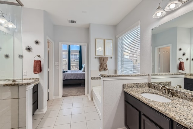 bathroom with tile patterned flooring, vanity, and a washtub