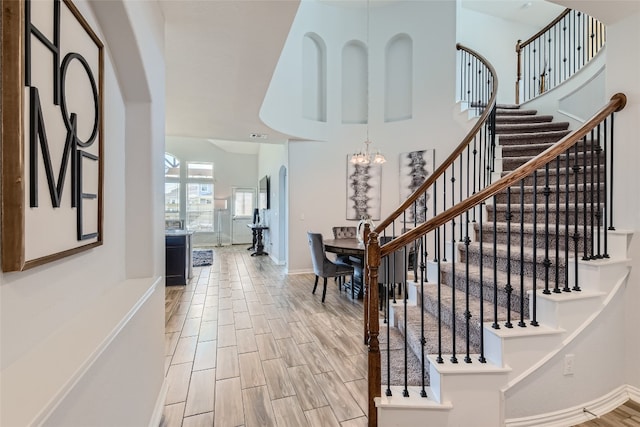 stairs featuring a chandelier and a towering ceiling