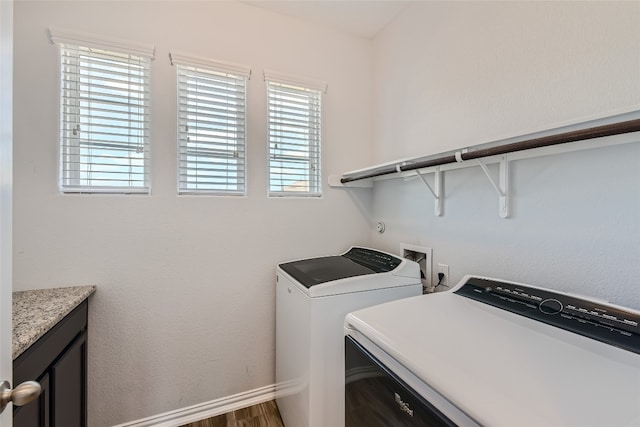 laundry room with dark hardwood / wood-style flooring, independent washer and dryer, and a wealth of natural light