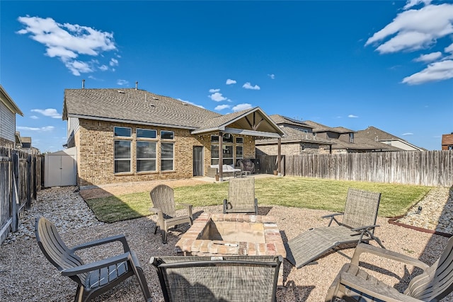 back of house featuring a yard, a shed, and a patio area