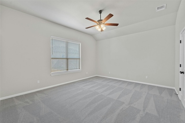 spare room featuring ceiling fan, lofted ceiling, and light colored carpet