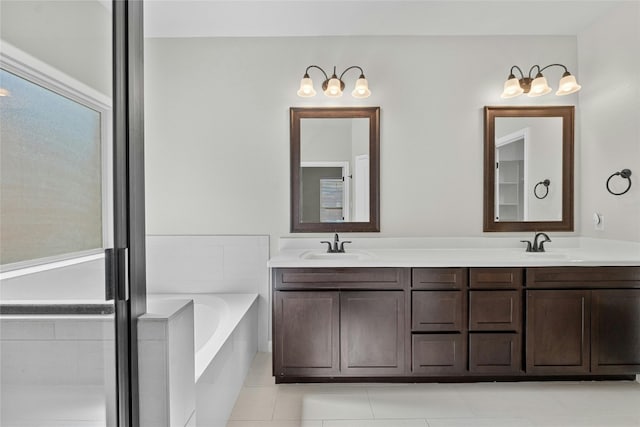 bathroom featuring vanity, tiled bath, and tile patterned flooring