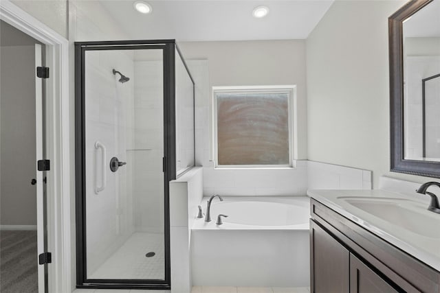 bathroom featuring vanity and independent shower and bath