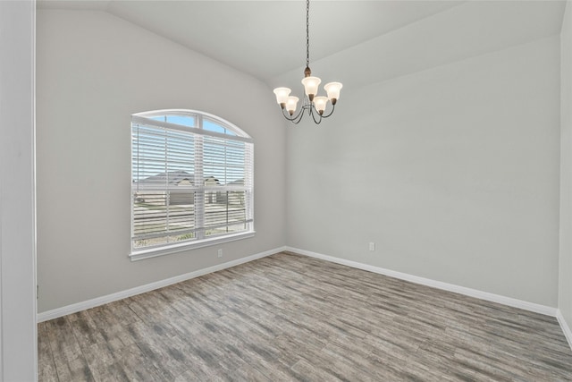 unfurnished room with an inviting chandelier, wood-type flooring, and vaulted ceiling