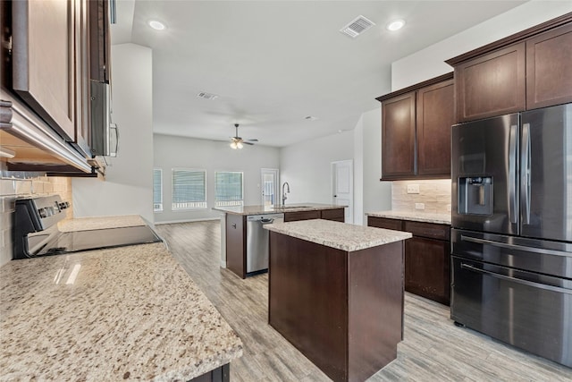 kitchen featuring a center island with sink, sink, light hardwood / wood-style flooring, and stainless steel appliances