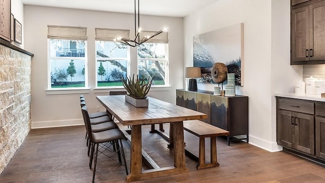 dining space with an inviting chandelier, dark wood-style floors, and plenty of natural light