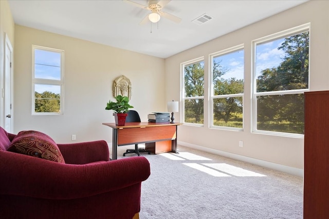 carpeted home office featuring ceiling fan