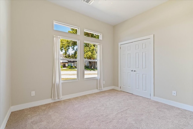 unfurnished bedroom with a closet and light colored carpet