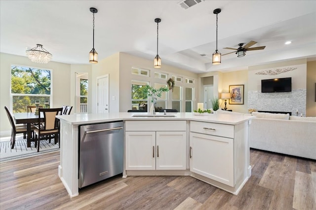 kitchen with dishwasher, a center island with sink, sink, white cabinetry, and light hardwood / wood-style floors