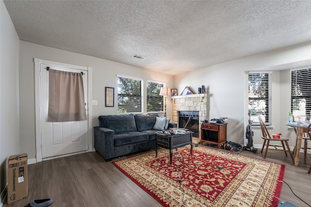 living room featuring a textured ceiling, dark wood-type flooring, and a wealth of natural light