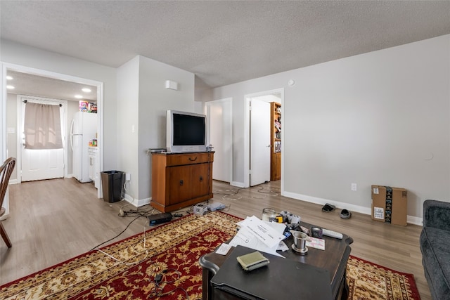 living room featuring light hardwood / wood-style flooring and a textured ceiling