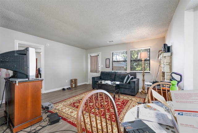 living room featuring light hardwood / wood-style flooring and a textured ceiling