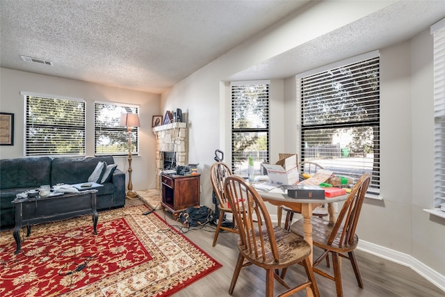 dining room with a wealth of natural light, a textured ceiling, and hardwood / wood-style flooring