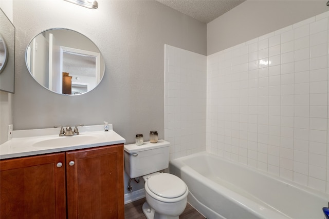 full bathroom featuring a textured ceiling, toilet, tiled shower / bath, vanity, and hardwood / wood-style flooring