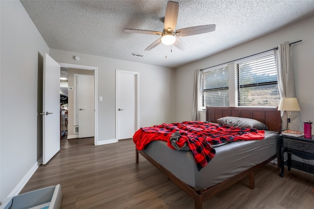 bedroom featuring ceiling fan, a textured ceiling, and dark hardwood / wood-style flooring